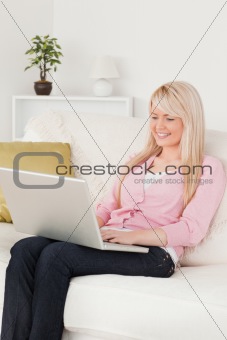 Young beautiful female relaxing with a laptop while sitting on a