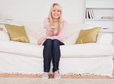 Beautiful blonde female posing while sitting on a sofa