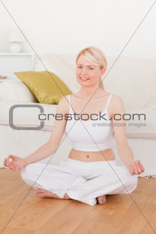 Young beautiful female doing yoga in the living room