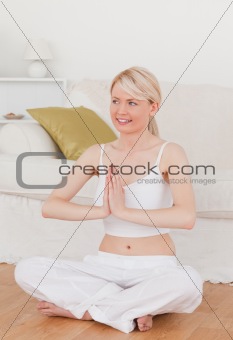 Young attractive female doing yoga in the living room