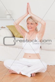 Young smiling woman doing yoga in the living room
