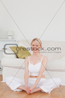 Young smiling woman doing relaxation exercises while sitting on 