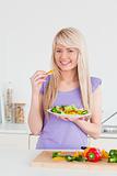 Attractive smiling female eating her salad 