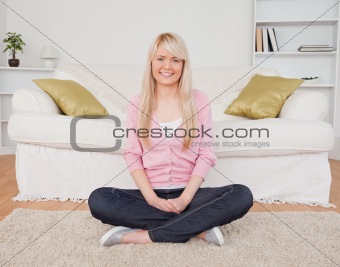 Beautiful blonde female posing while sitting on the floor