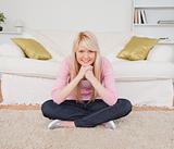 Beautiful blonde woman posing while sitting on the floor