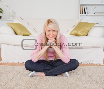 Beautiful blonde woman posing while sitting on the floor