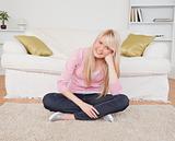 Attractive blonde female posing while sitting on the floor