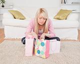 Blonde woman sitting in the living-room with her shopping bags