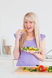 Attractive smiling woman eating her salad 