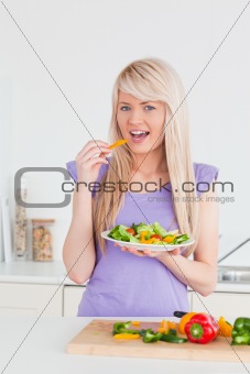 Attractive smiling woman eating her salad 