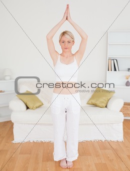 Attractive blonde woman stretching in the living room