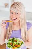 Beautiful smiling female eating her salad