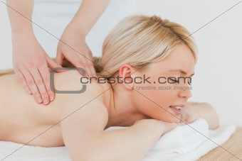 Closeup of young attractive blonde woman receiving a back massag