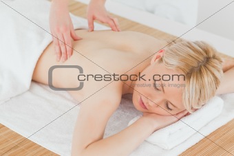 Closeup of young gorgeous blonde female receiving a back massage