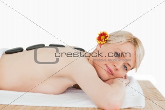 Beautiful blonde woman relaxing with hot stones on her back