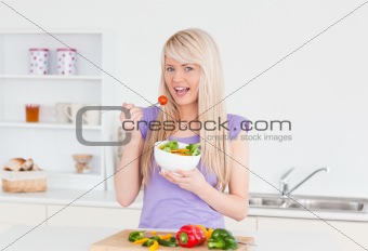Blonde smiling female eating her salad