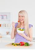 Blonde smiling woman eating her salad