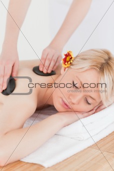 Beautiful woman receiving a massage with hot stones