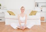 Smiling blond-haired woman practicing yoga