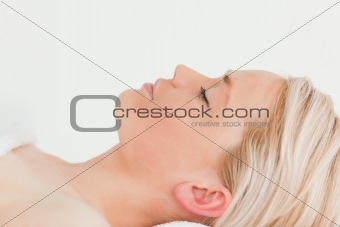 Attractive blond-haired woman relaxing while lying down