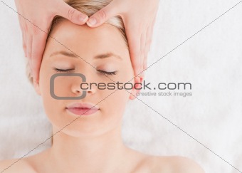 Delighted young woman getting a massage on her face