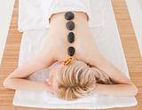 Young blonde woman relaxing with hot stones on her back