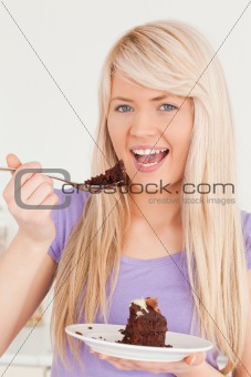 Smiling blonde female eating cake