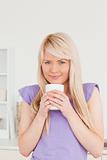 Attractive blonde female drinking hot drink