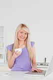 Attractive blonde woman holding a cup of coffee and relaxing on 