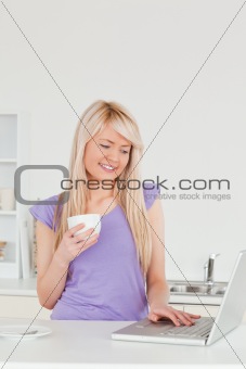Attractive blonde female holding a cup of coffee and relaxing on