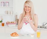 Attractive blonde female having her breakfast in the kitchen