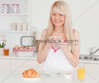 Attractive blonde female having her breakfast in the kitchen
