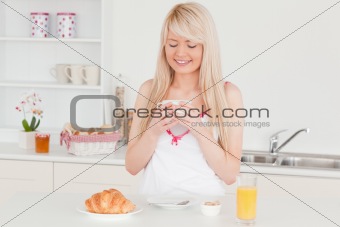 Gorgeous blonde woman having her breakfast in the kitchen
