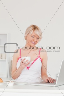 Good looking female having her breakfast while relaxing with a l