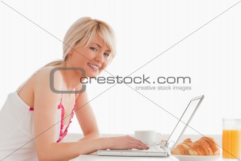 Beautiful smiling female having her breakfast while relaxing wit