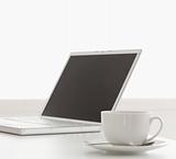 Modern laptop and cup of tea on a table