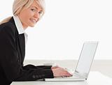 Professional woman posing while relaxing on a laptop