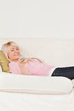 Good looking blonde female posing while lying on a sofa