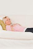 Good looking blonde woman posing while lying on a sofa