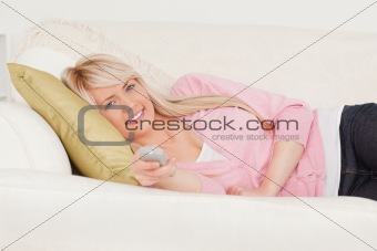 Attractive blonde female posing while lying on a sofa