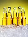 Glass of beer with foam on yellow background