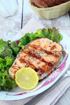 red fish salmon grilled with lemon and salad