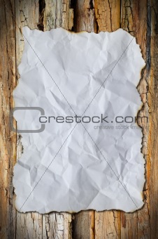 white crumpled paper and border burn on wood background