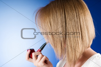 Girl smoking pipe against the gradient background