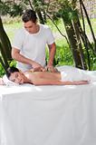 Man giving massage to woman by a wooden massager
