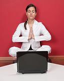 Businesswoman meditating in yoga lotus position