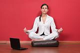Businesswoman sitting in yoga lotus position