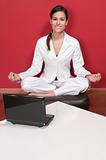 Smiling businesswoman sitting in yoga lotus position