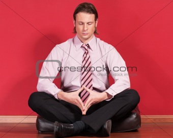 Businessman meditating on the floor
