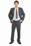 Full length portrait of modern young businessman with hands on hips
